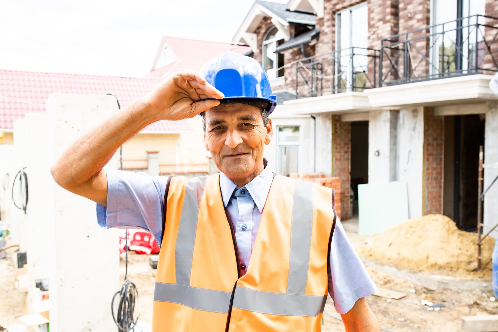 people working in construction site. Portrait of happy indian man at work in new house.